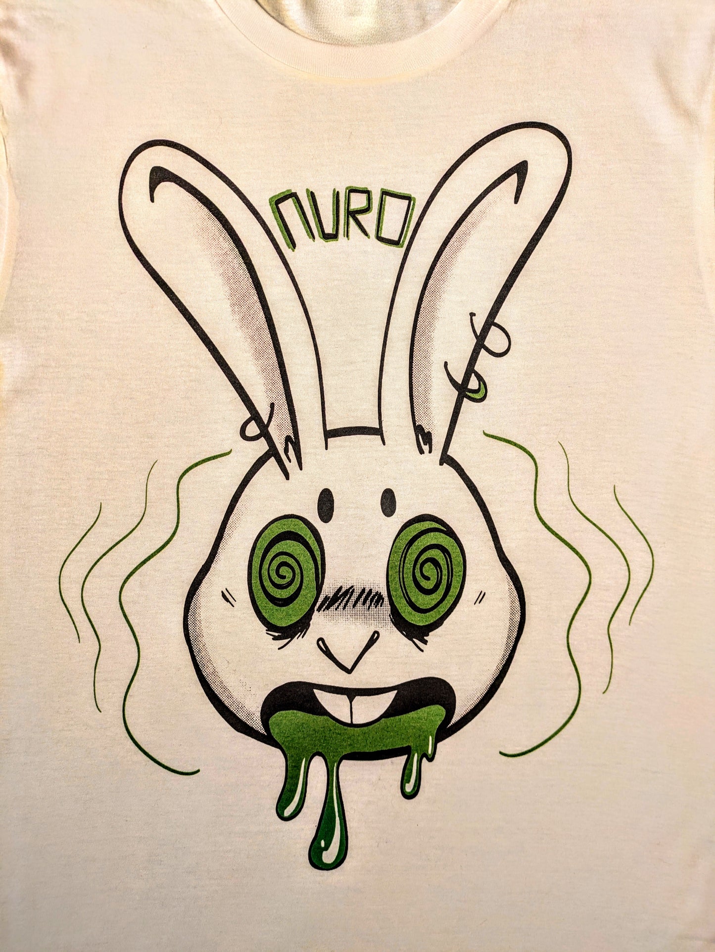 T-shirt with a graphic design of a pierced rabbit with hypnotized green eyes and open mouth and green drool