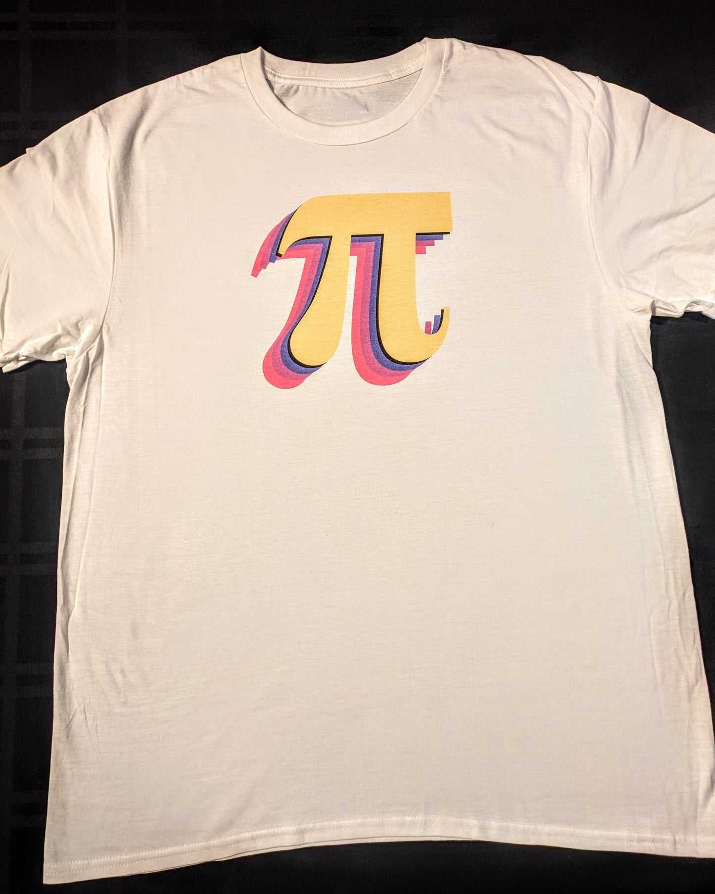 White t-shirt with golden pi symbol featuring a blue purple and pink dropshadow 