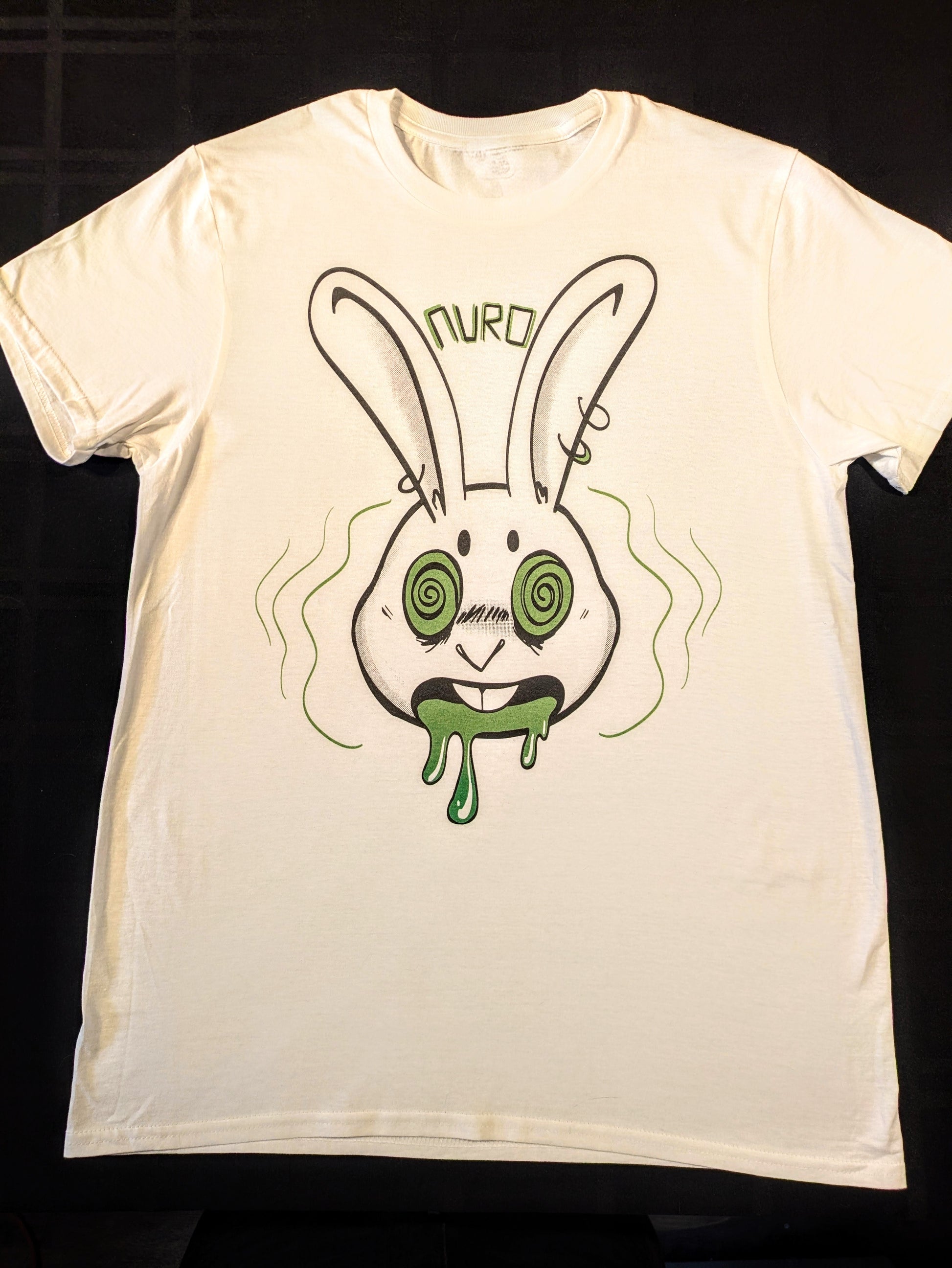White t-shirt with a pierced anthro rabbit with green hypnotized eyes, open mouth and green drool with block letters between the ears spelling Nuro