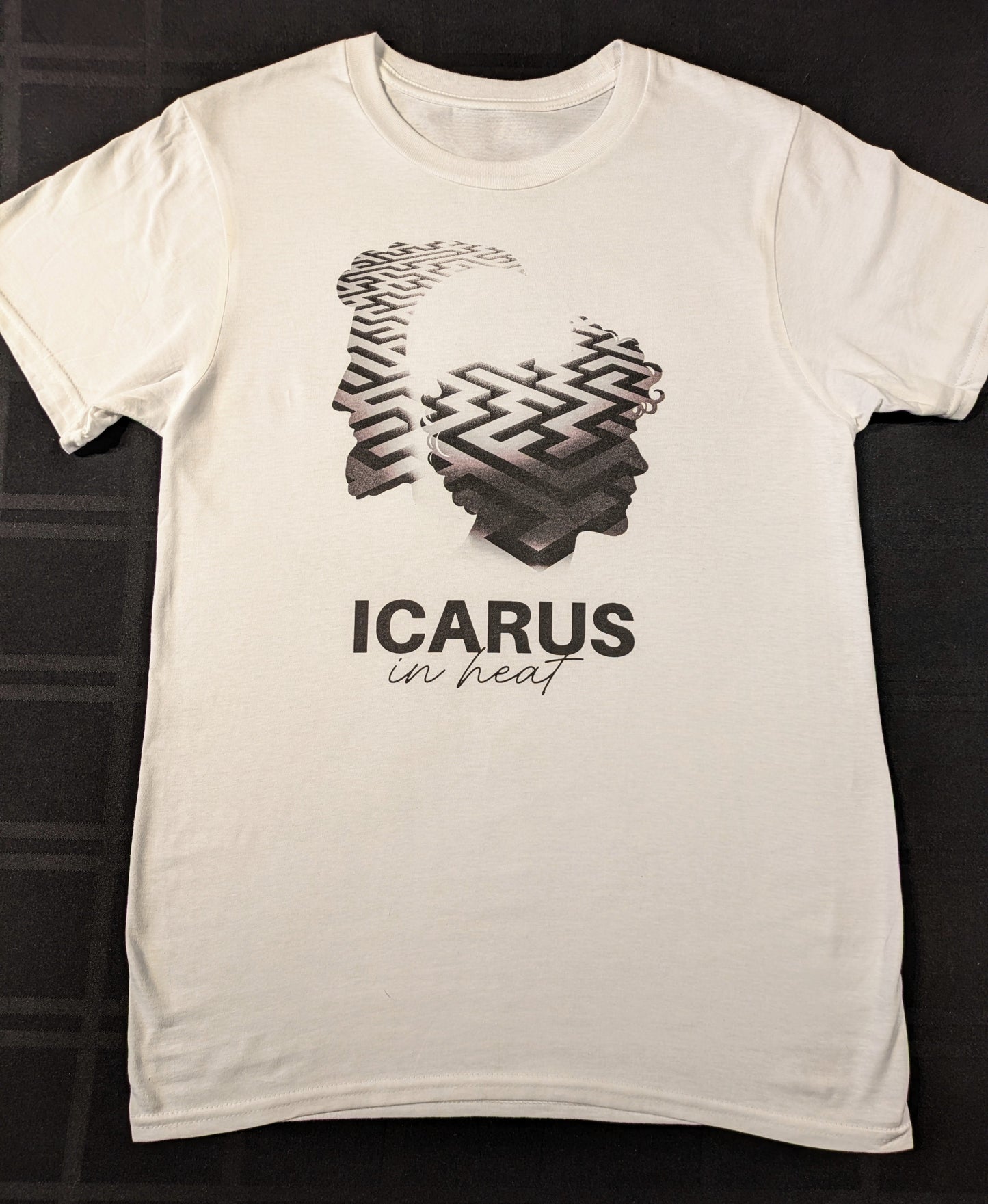 White t-shirt with black graphic design of an older male silhouette and a younger male silhouette with a maze inside the shadow and 'ICARUS in heat' text underneath