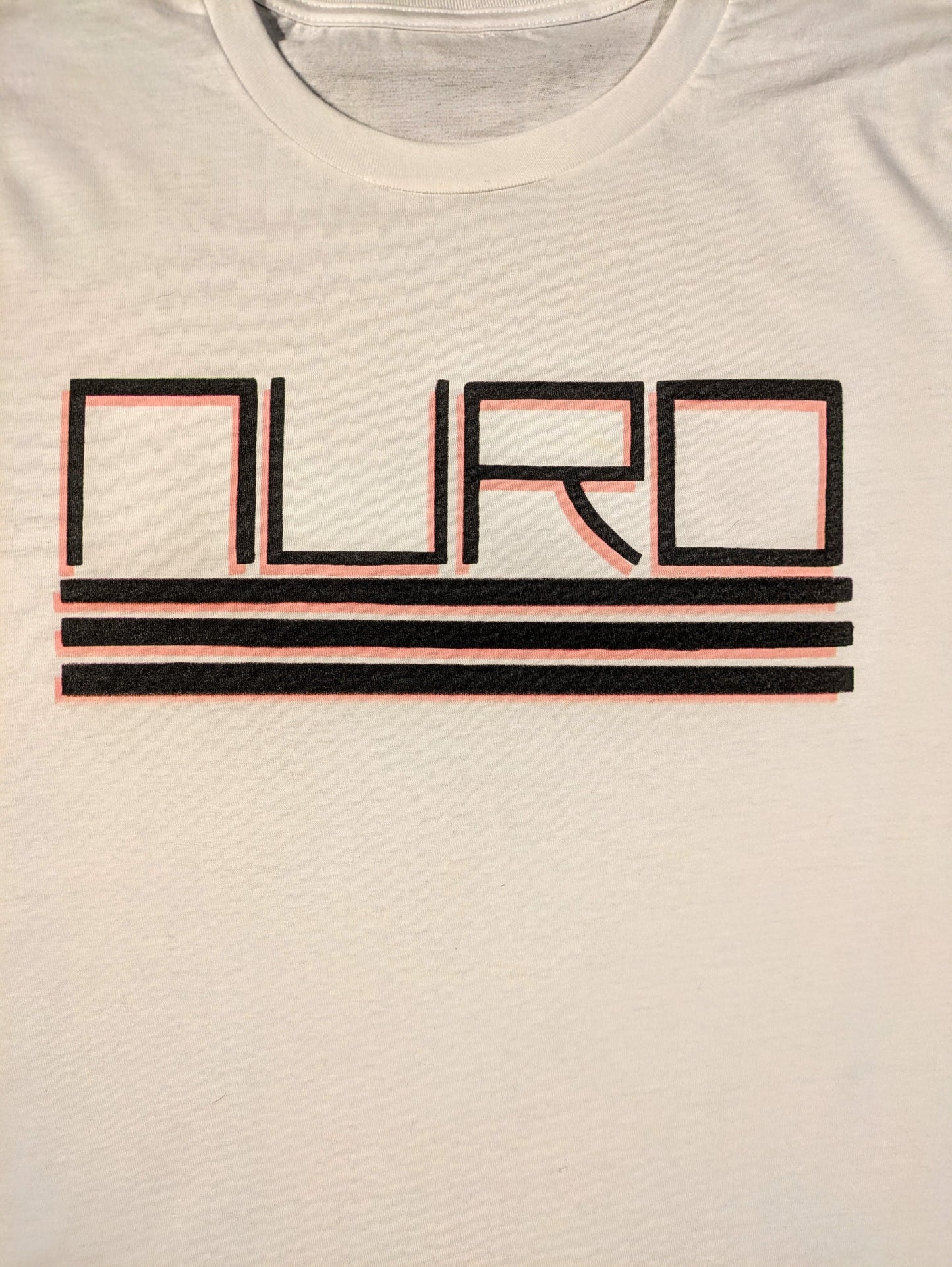 White tee with NURO in bold black squared letters with three lines underneath and a red drop shadow